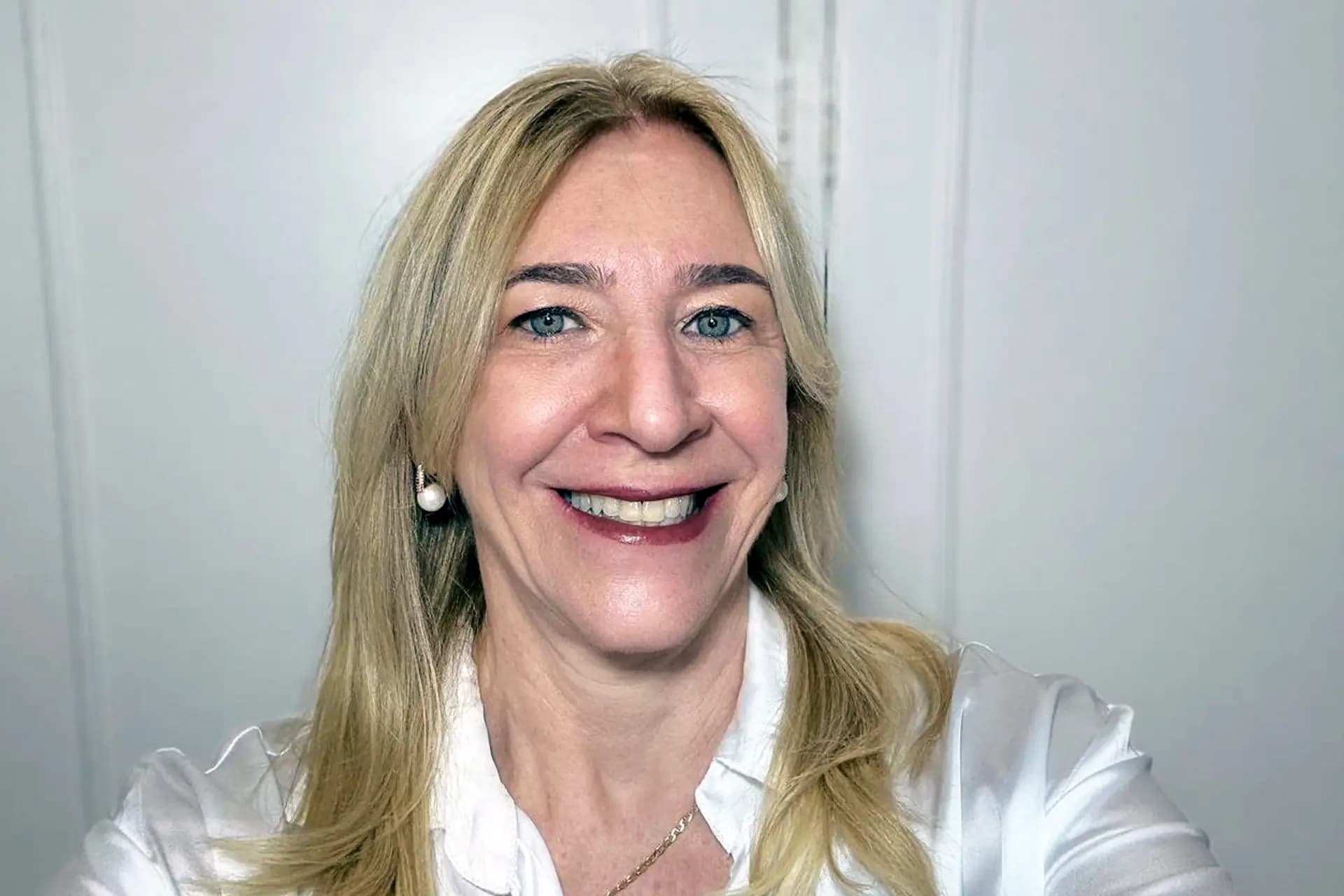 Retrato de Brunete Gildin com camisa branca e fundo claro