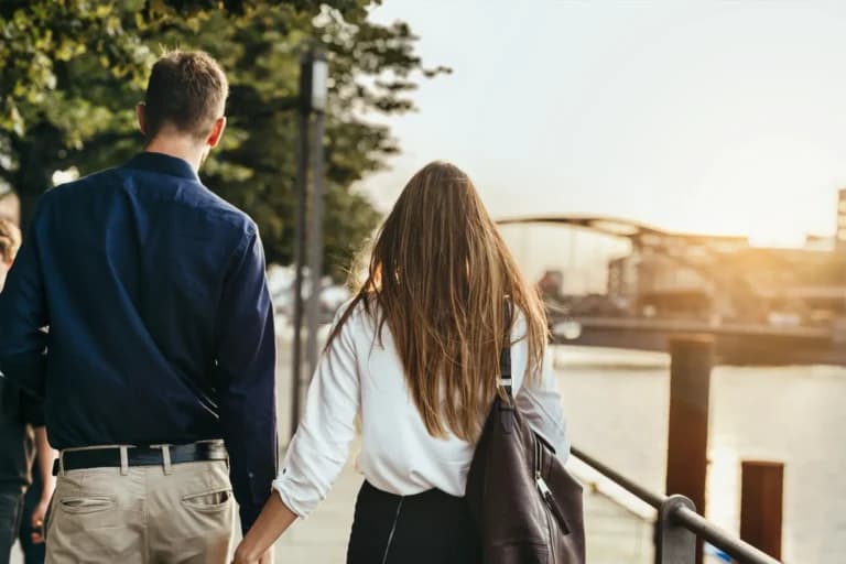 Casal caminhando de mãos dadas ao ar livre